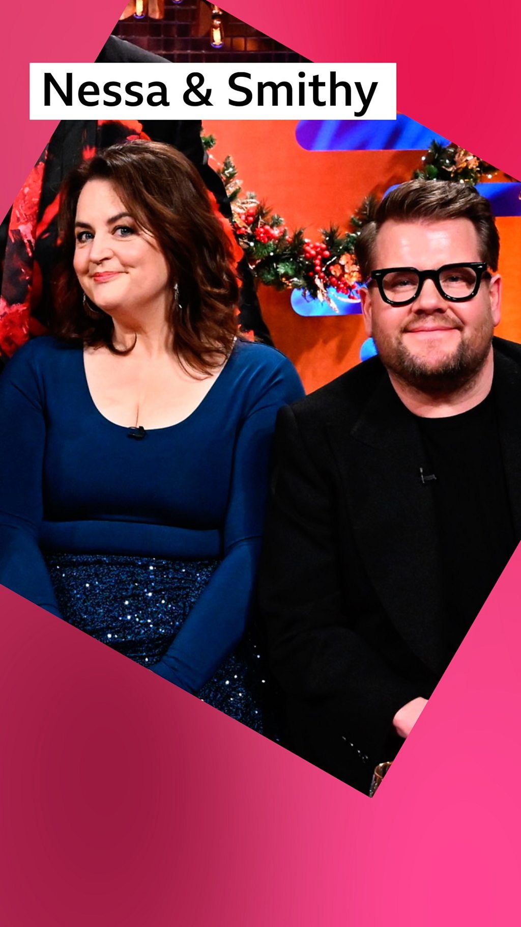 A woman and a man, Ruth Jones and James Corden, sit on a sofa - she wears a blue top and skirt, he wears a black suit