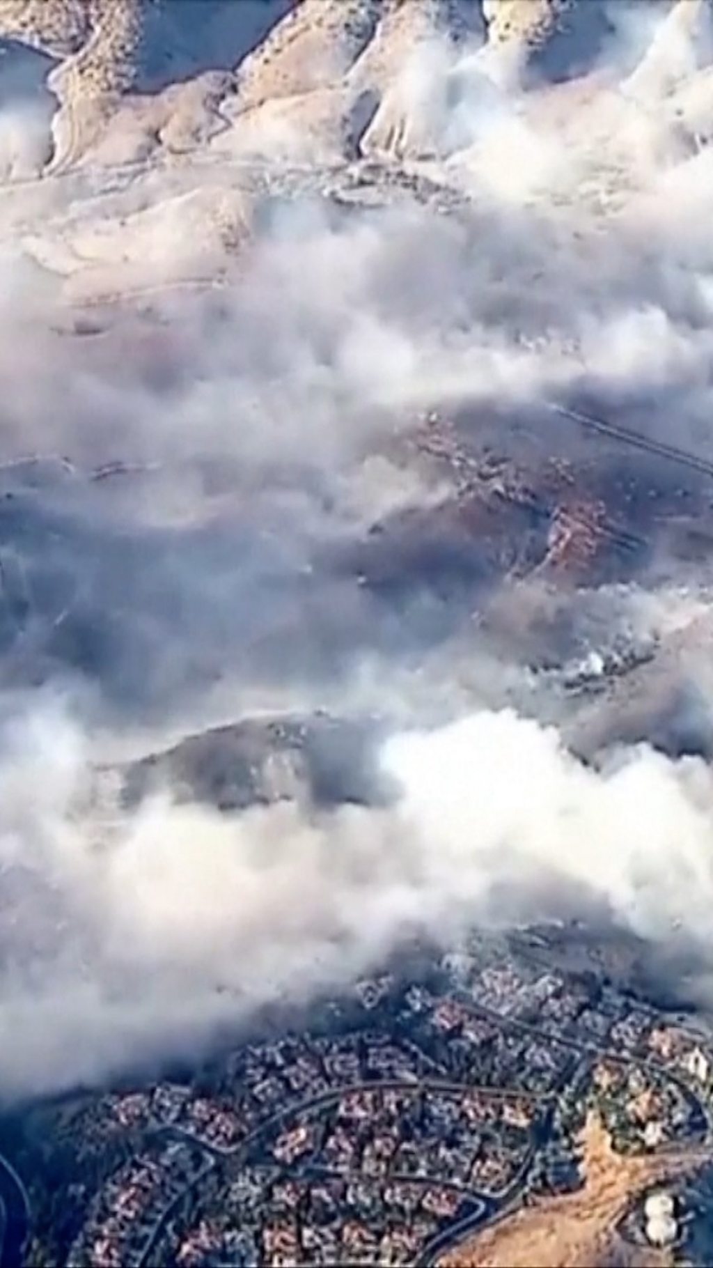 Aerial view of smoke billowing from fires burning near homes in LA