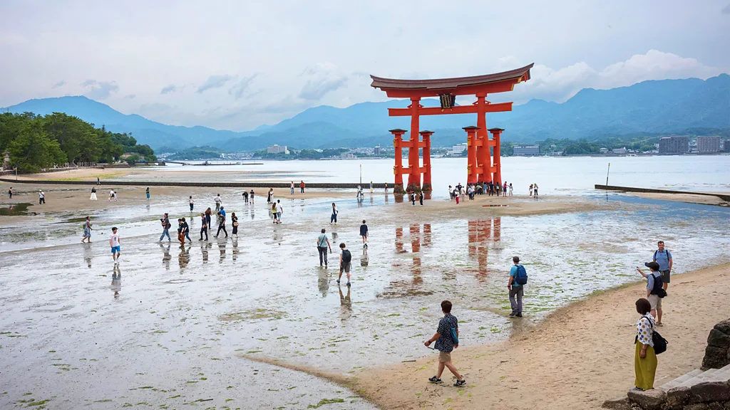 People walk along a beach in Japan