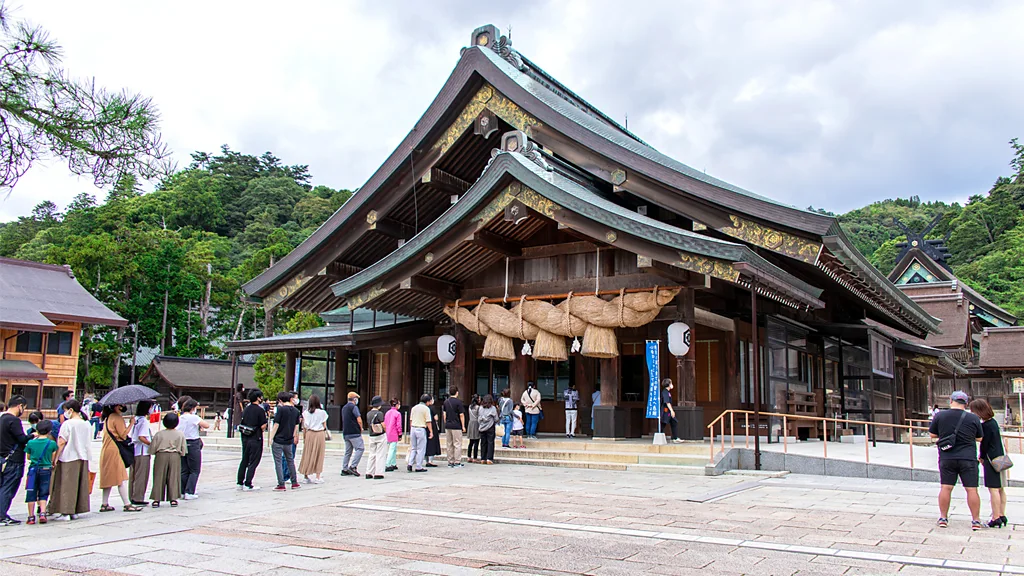 People walking under the bronze arch at Izumo Taisha Shrine (Credit: Getty Images)