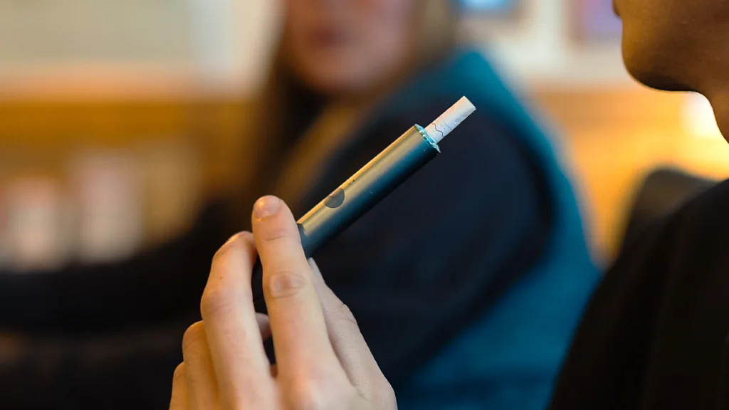 Close up of a hand holding a heated tobacco device (Credit: Getty Images)