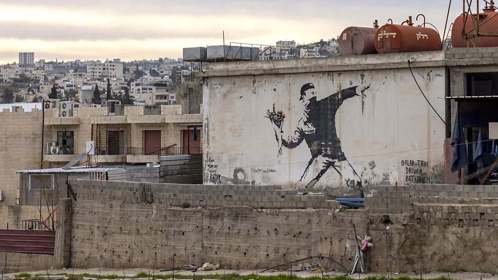 A man taking a photo of Banksy's new mural Lighthouse in Marseille, with text that reads "I want to be what you saw in me" (Credit: Photo of Lighthouse, 2025/ Alamy)