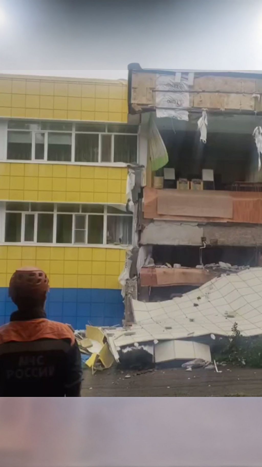 Спасатель смотрит на разрушенный дом