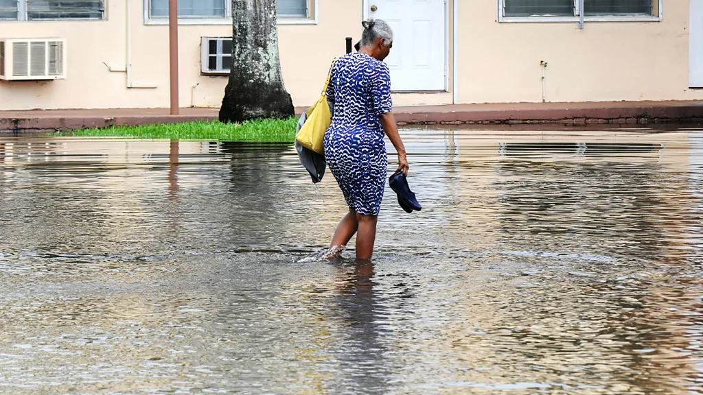 A house is surrounded by floodwater and four submerged cars (Credit: Getty Images)