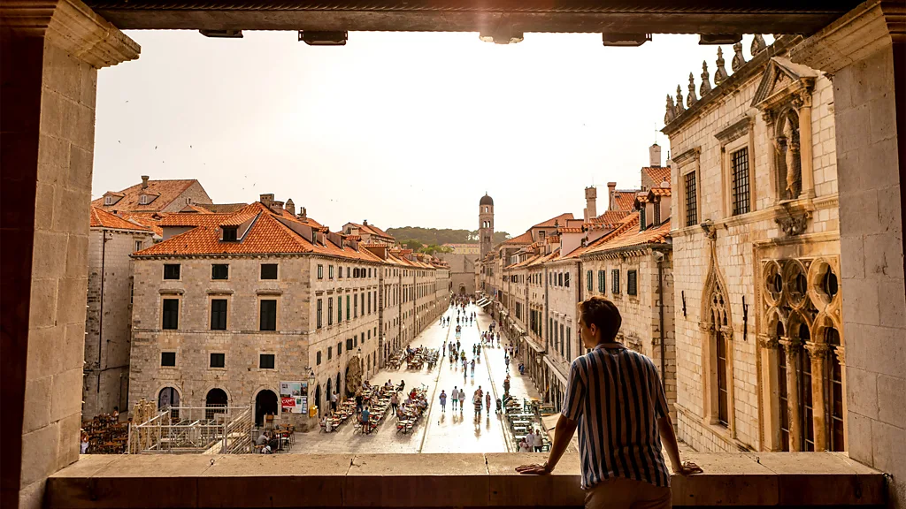 View of Dubrovnik's medieval stone walls and terracotta rooftops with sea and boats in foreground (Credit: Yuya Matsuo)