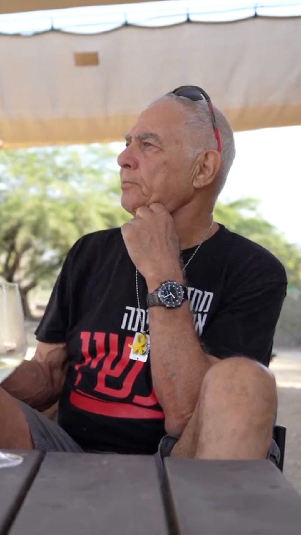 Самый пожилой заложник ХАМАС, который вернулся обратно, сидит за столом и смотрит вдаль.