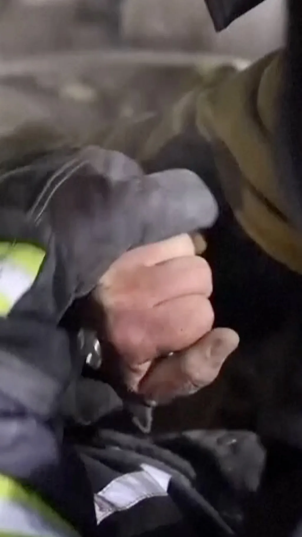 Рука спасатели держит руку пострадавшего под завалами