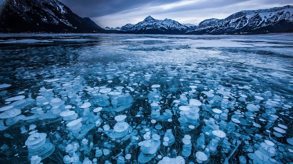 The rail trail passes near Alberta's Abraham Lake and its otherworldly bubbles (Credit: Alamy)