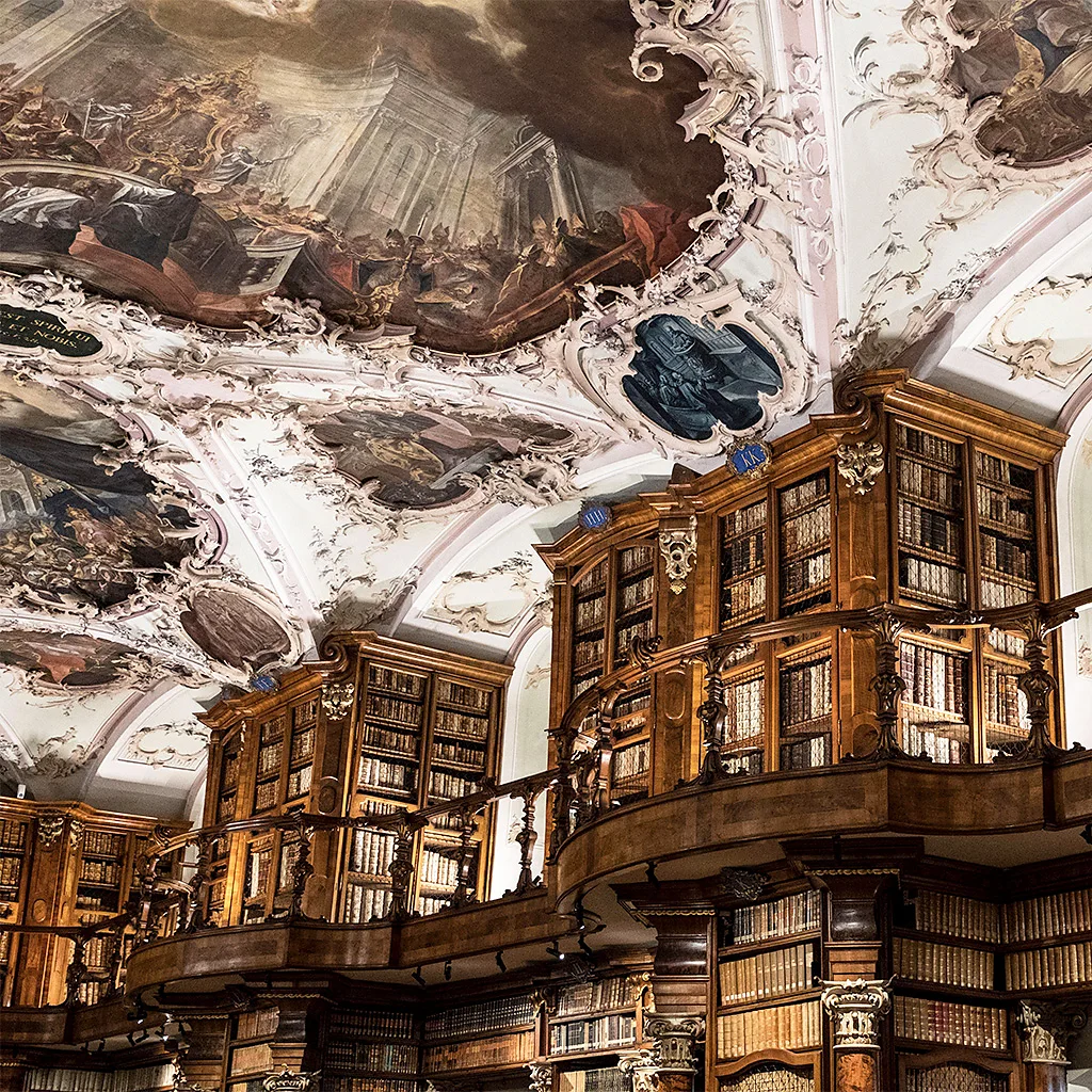The fantastical décor includes ornate wooden bookcases and a painted Baroque ceiling (Credit: Alamy)