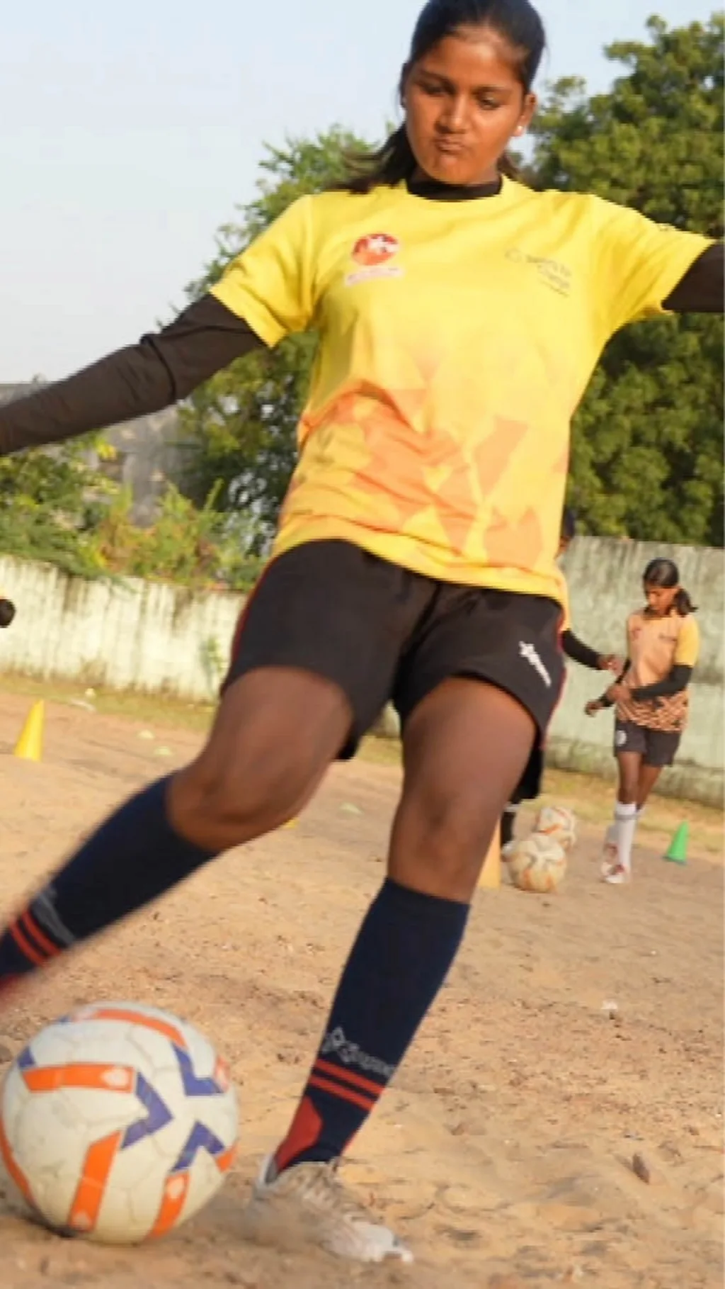 devojcica sutira fudbalsku loptu