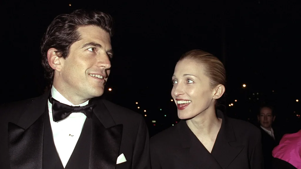 John F Kennedy Jr and Carolyn Bessette smiling at each other (Credit: Getty Images)