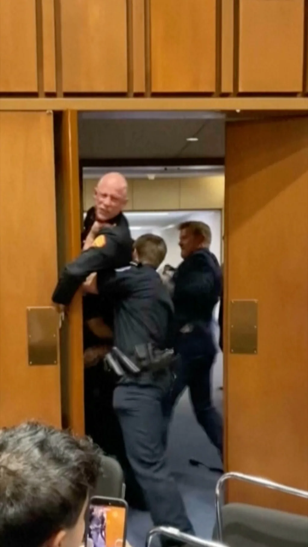 Полиция выводит мужчину из зала