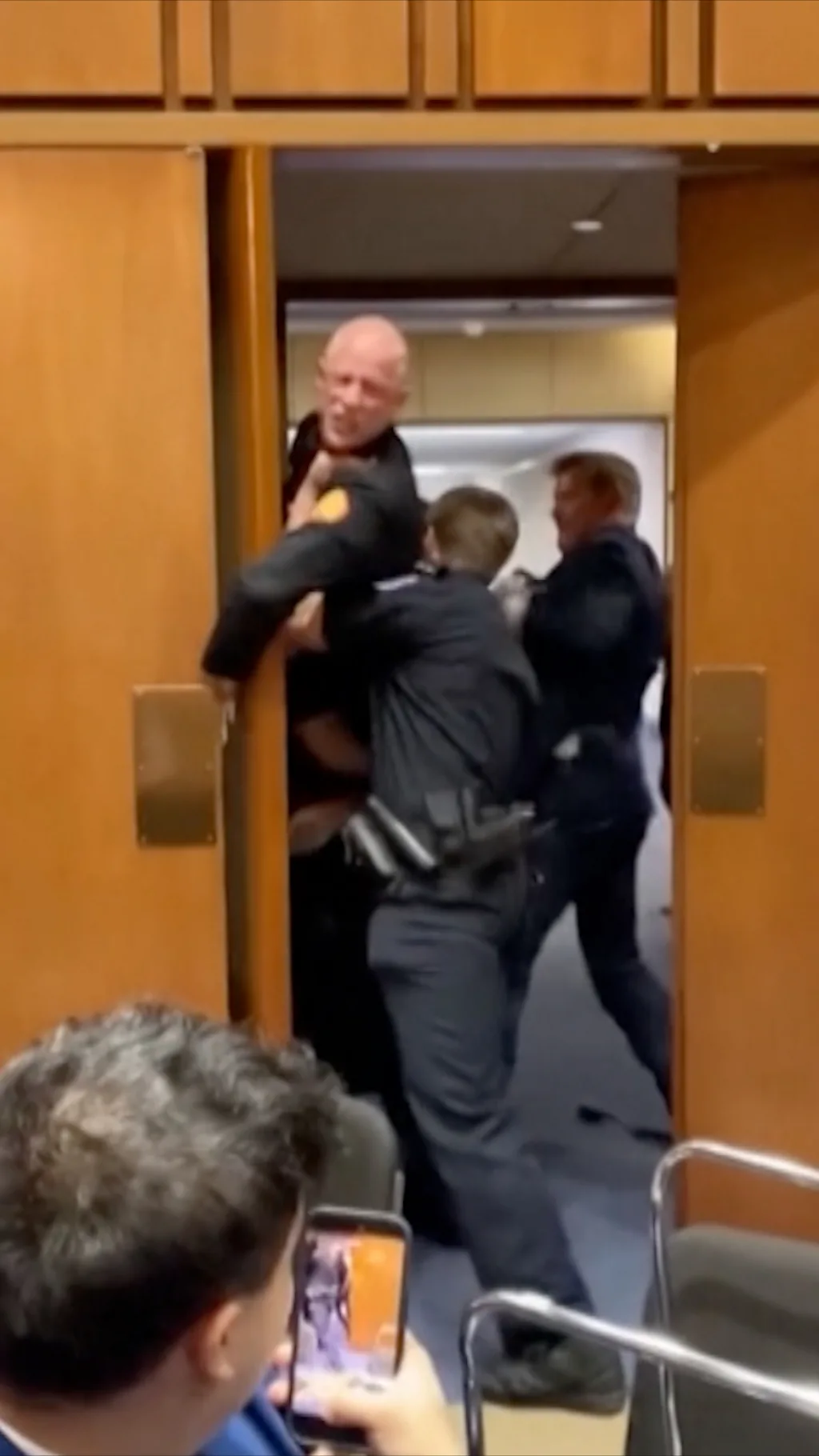 obezbedjenje gura muskarca kroz vrata