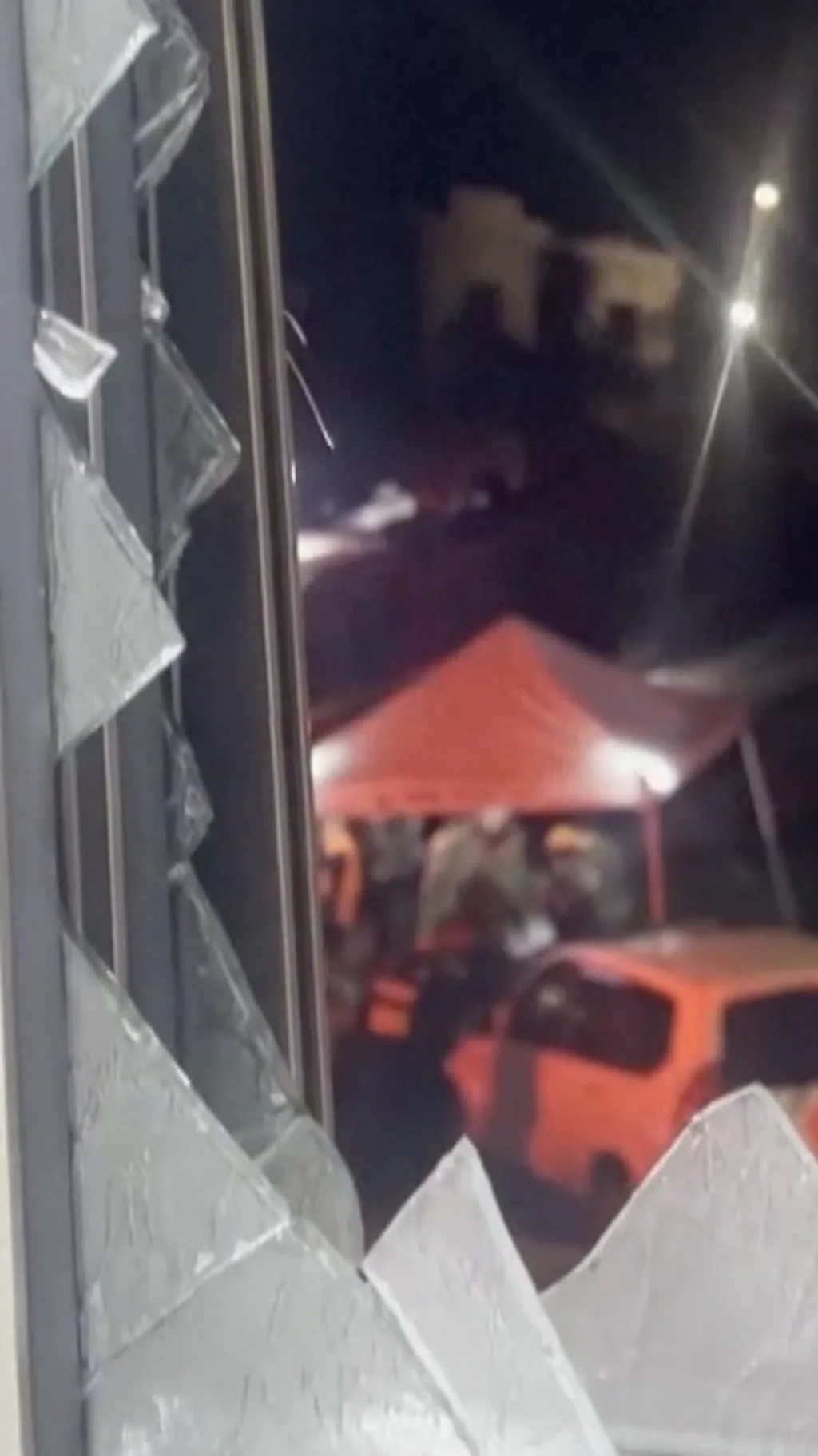 разбитое окно сквозь которое видны проблесковые маяки спасателей