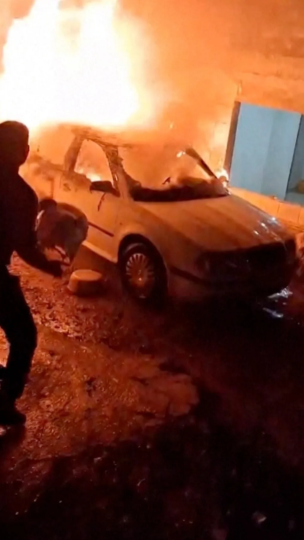 Мужчина тушит горящую машину