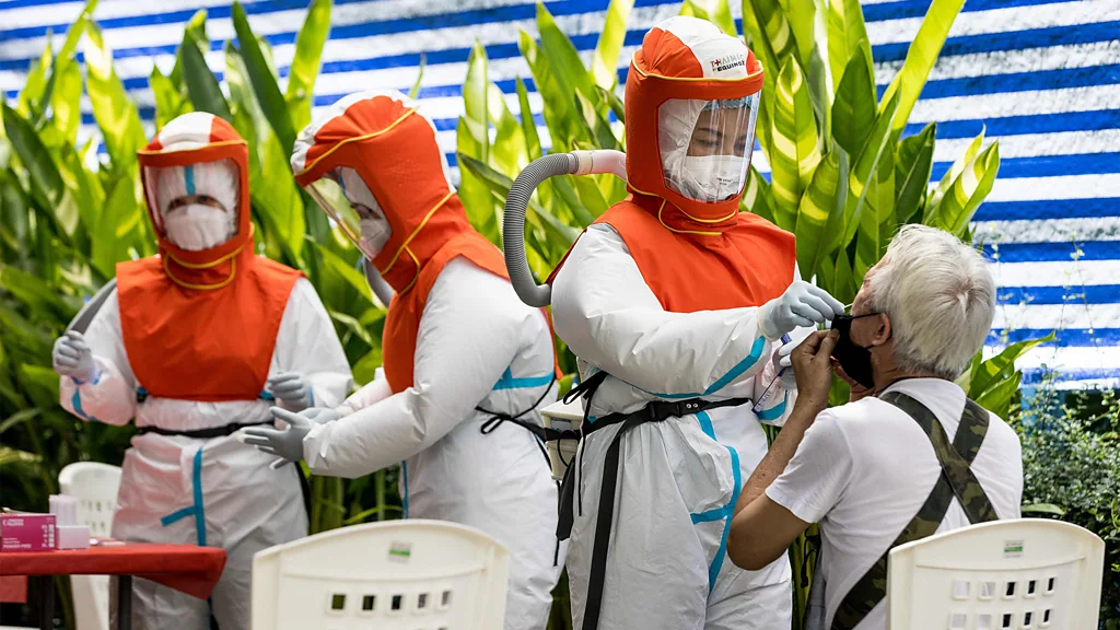 Medic in protective clothing with arms extended receiving deep clean (Credit: Getty Images)