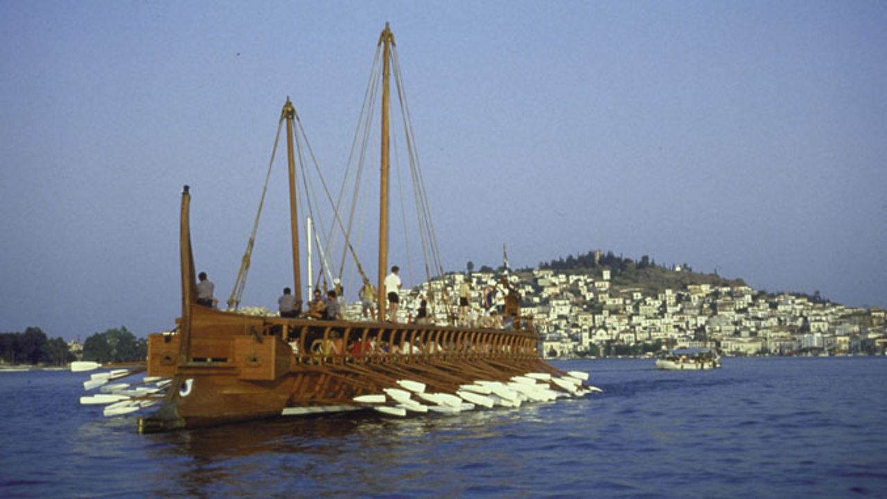 A replica ancient Athenian warship trireme with volunteer British crew manning oars.