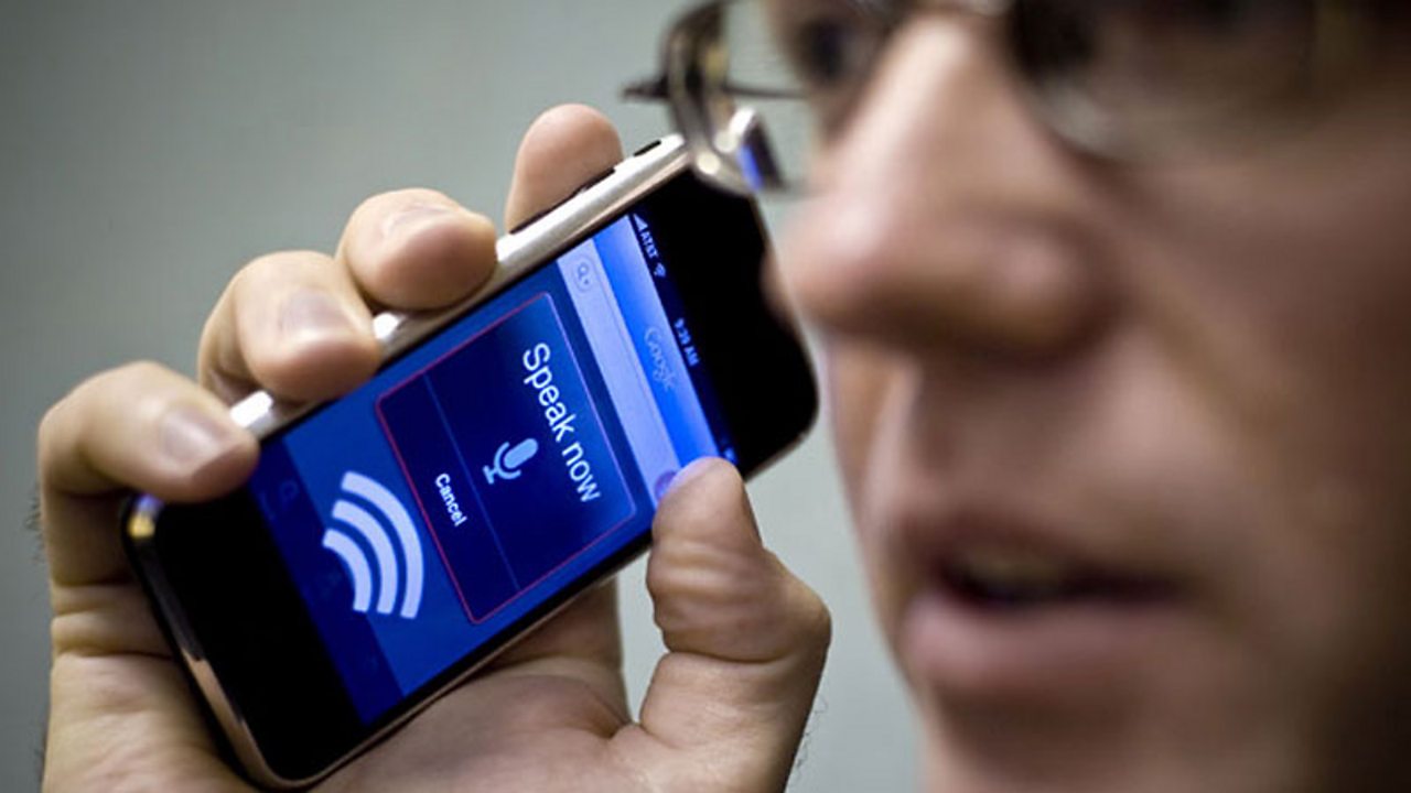 Man speaking into a smartphone with voice recognition technology.