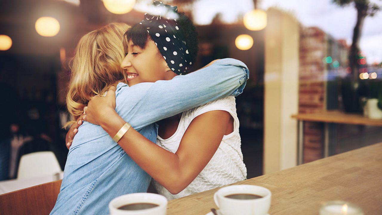 Two women hugging one another.