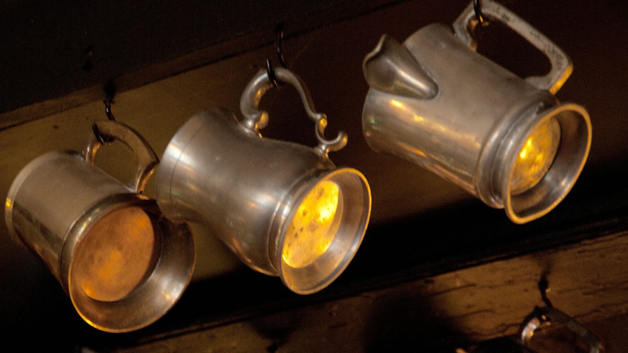 A set of three ale tankards on hooks