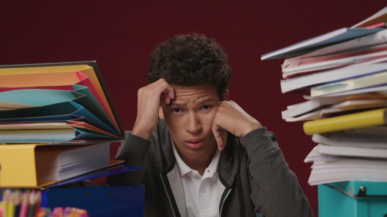 Boy sat between filed stacked up high