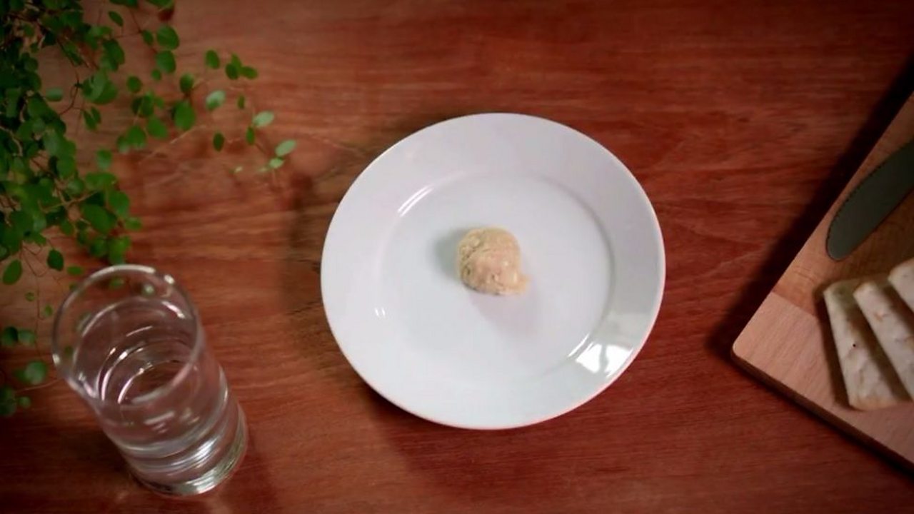 An image of cracker mush on a plate next to a glass of water