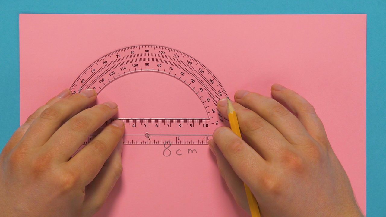 Someone drawing out 8cm with a protractor