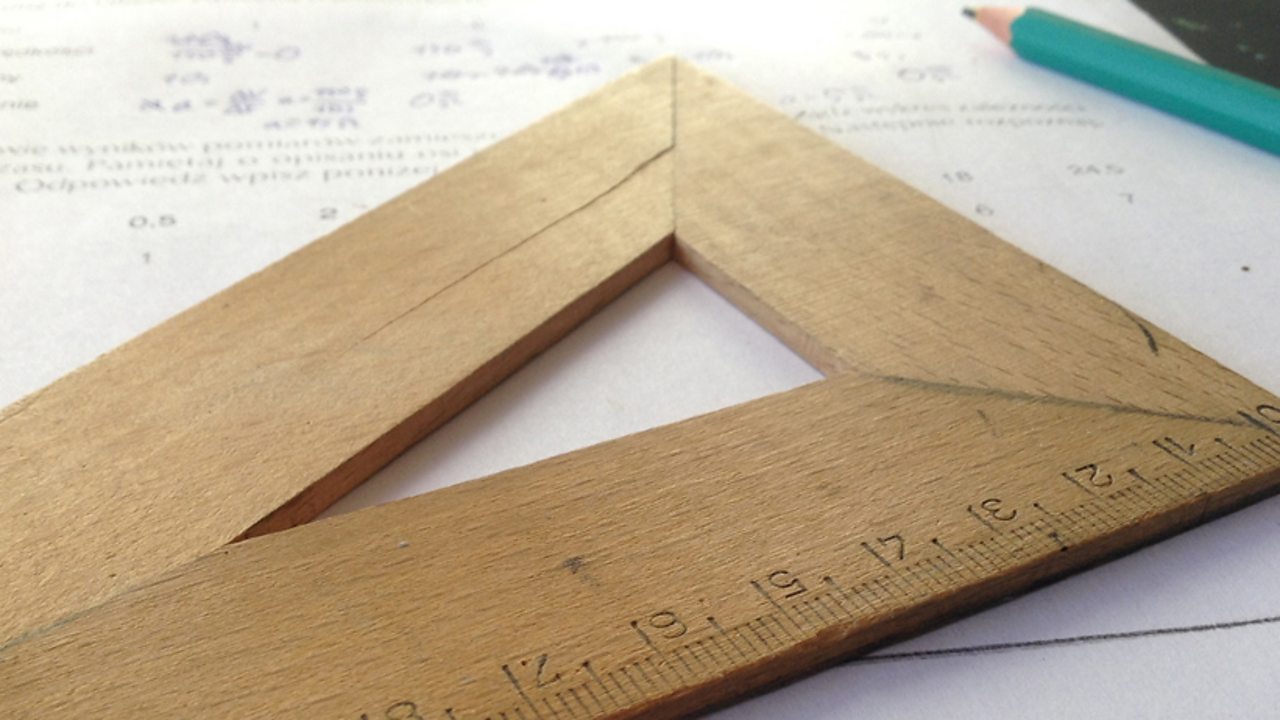 A close up of a wooden set square.