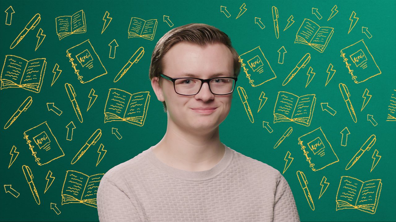 A young man sits looking directly at the camera