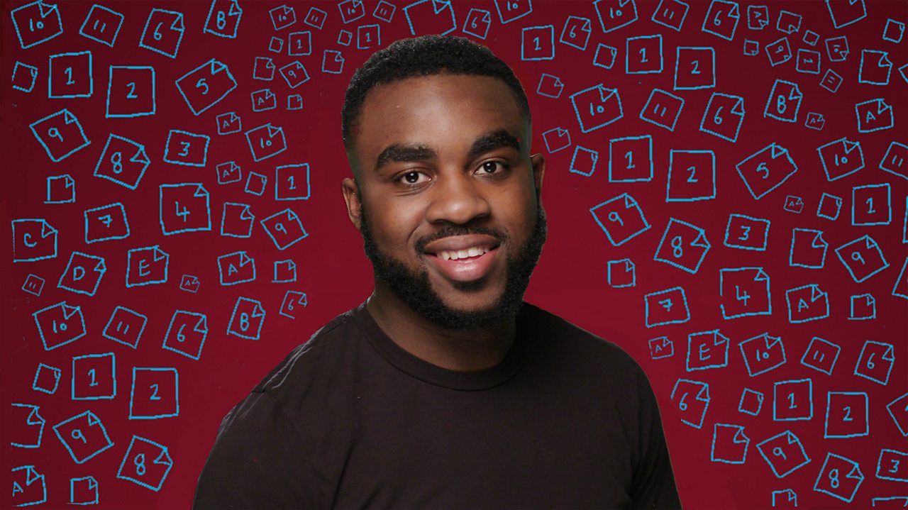 A young man sits looking directly at the camera