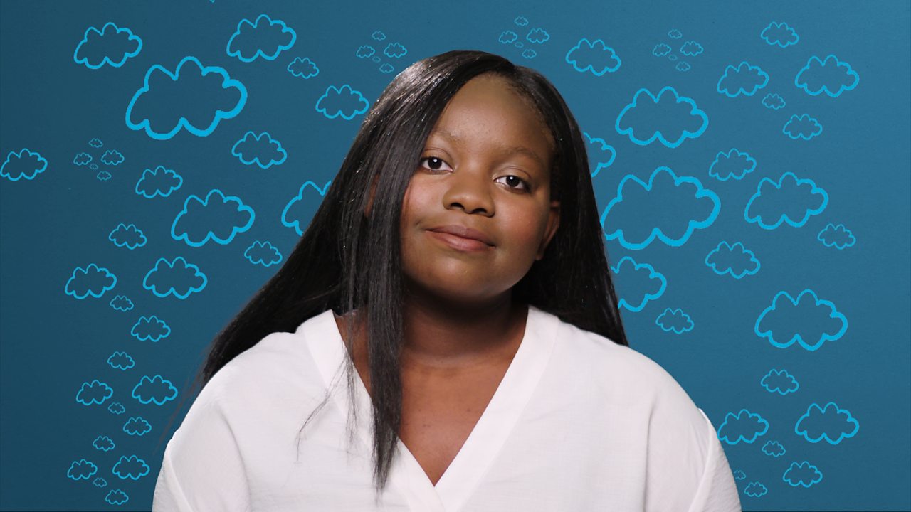 A young woman sits looking directly at the camera