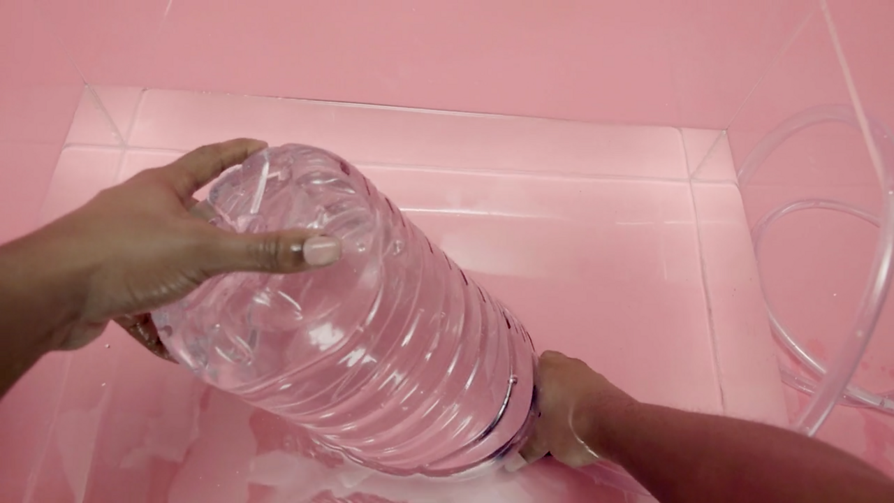 Place the now full bottle upside down into a container full of water. Without lifting the bottle out of the water, place the tube into the bottle.