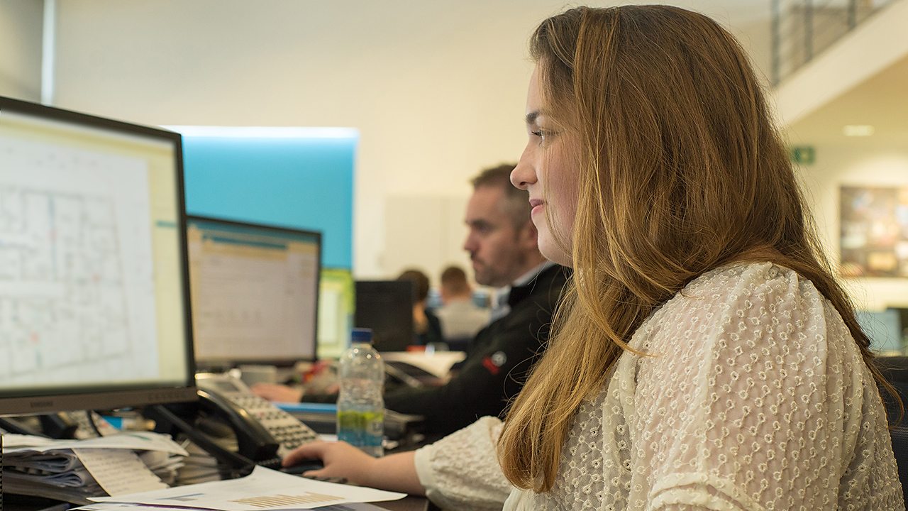 A young woman, Aine, working on her computer in an office environment