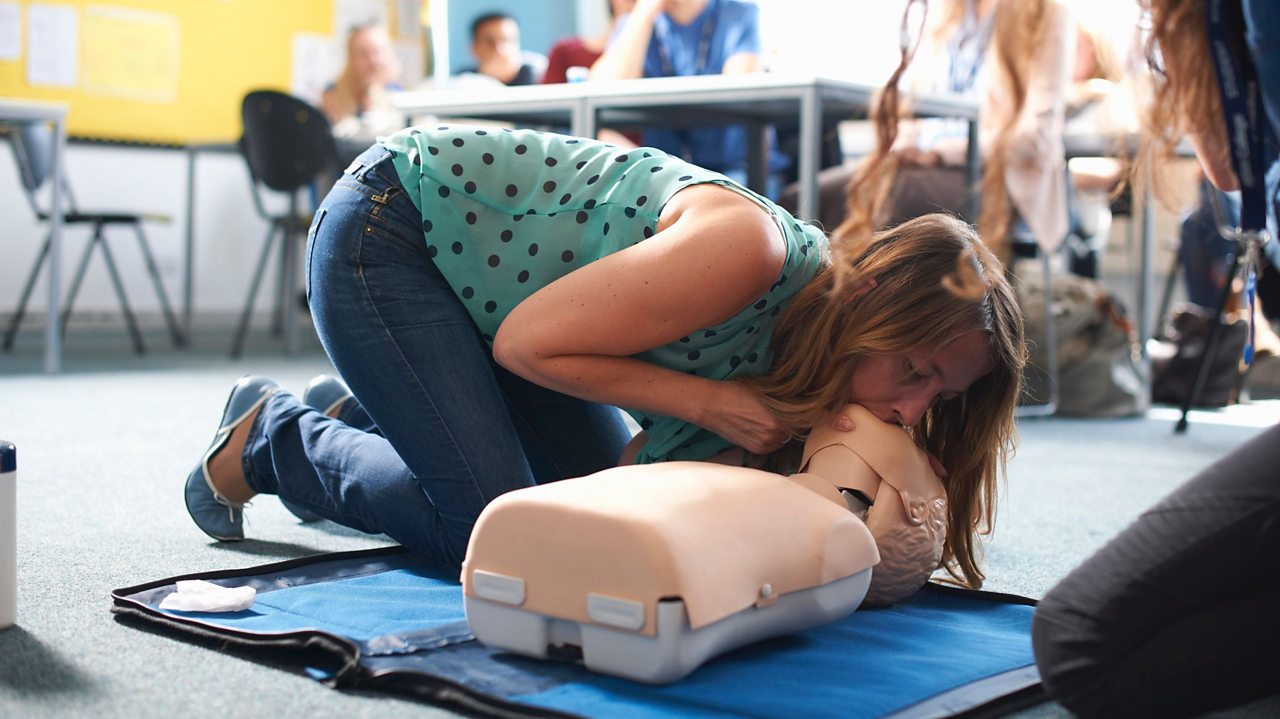 Woman giving CPR to a doll