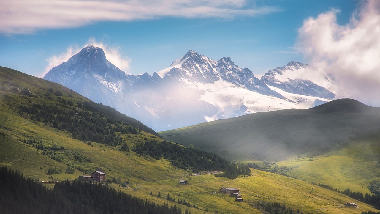 The Alps are made up of lower grassland hills and higher snow-capped mountains.