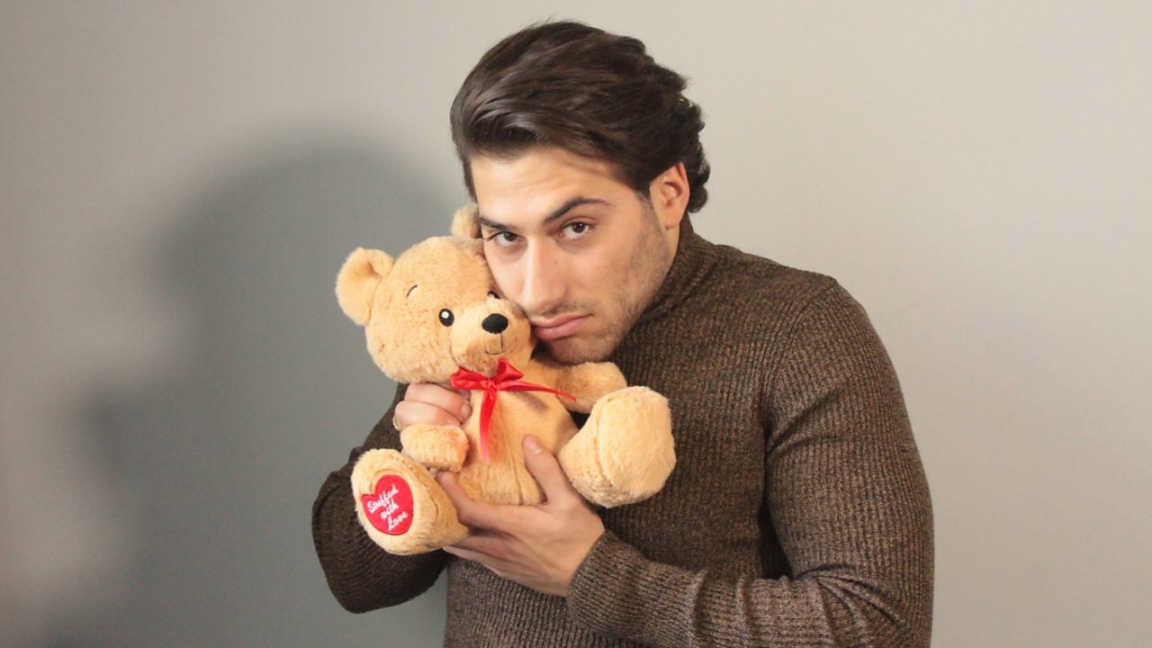 Kem Cetinay looking sad with a teddy bear