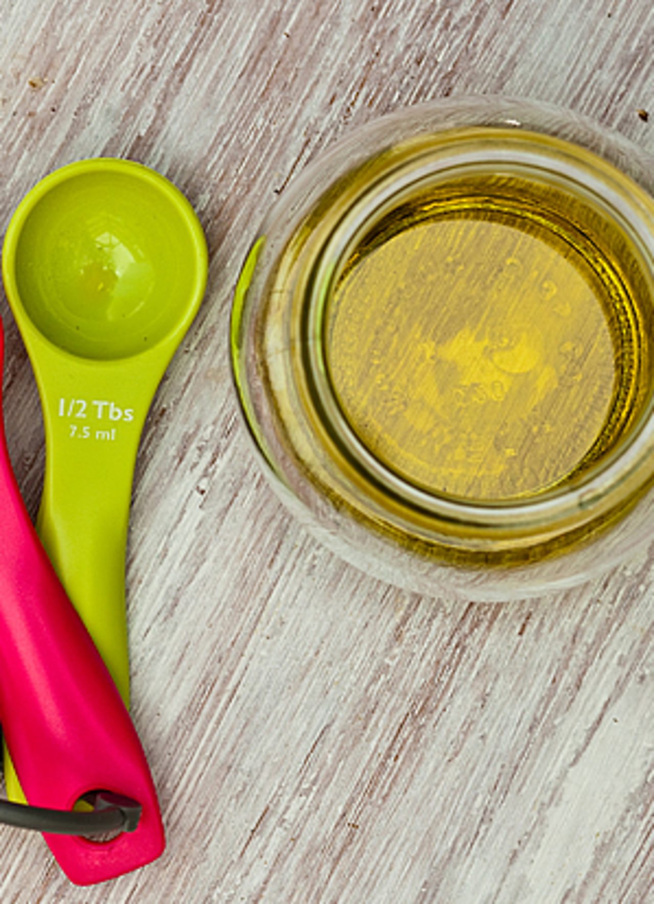 olive oil in bowl with measuring spoon
