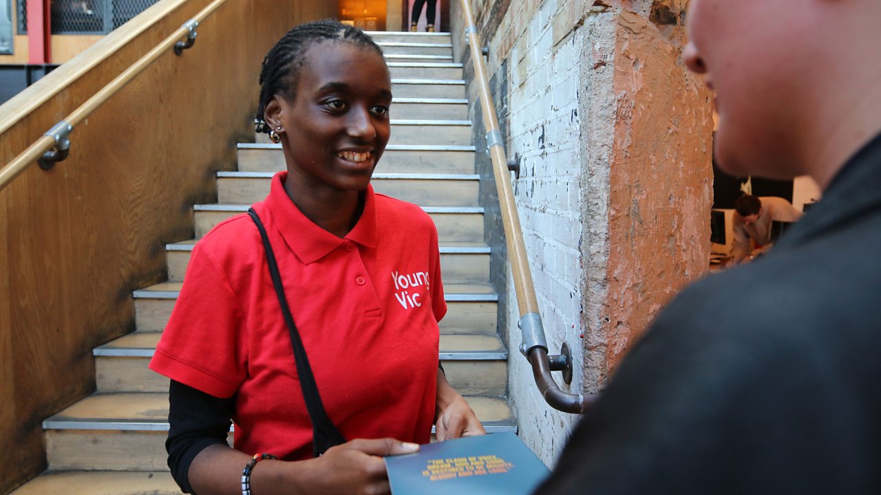 Aisha speaking to a theatregoer.