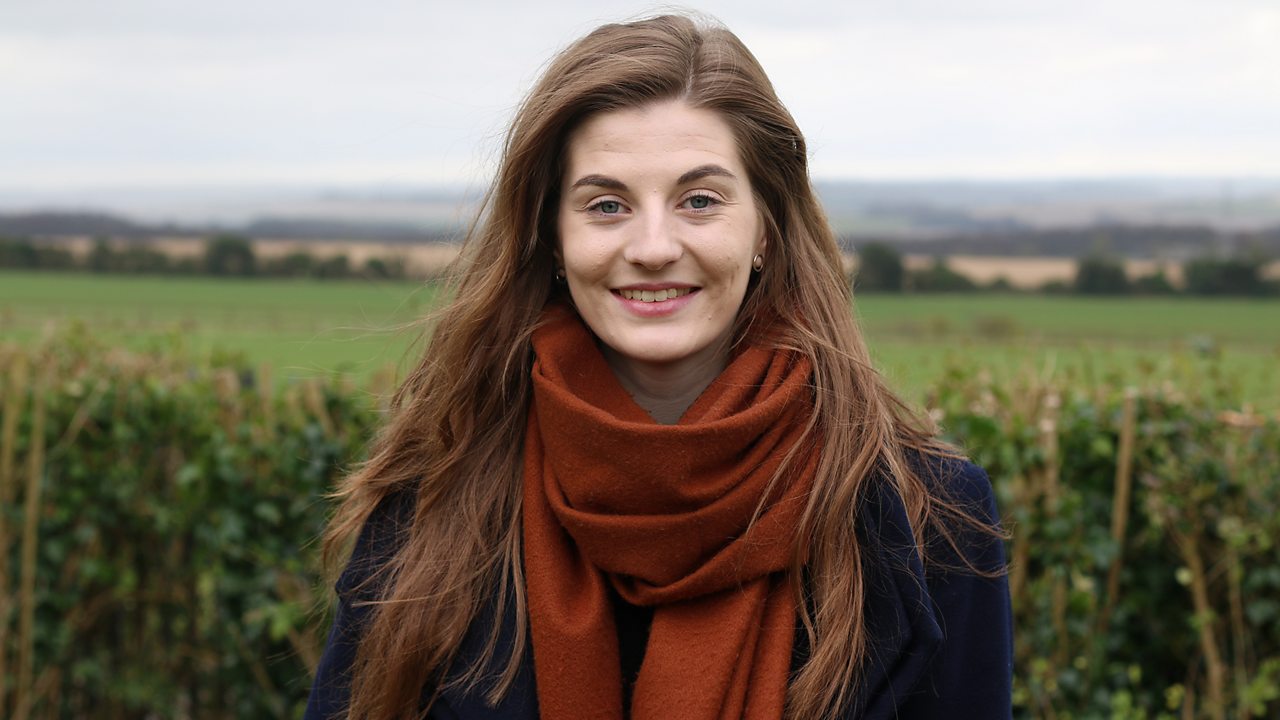 Alex standing in front of a field.