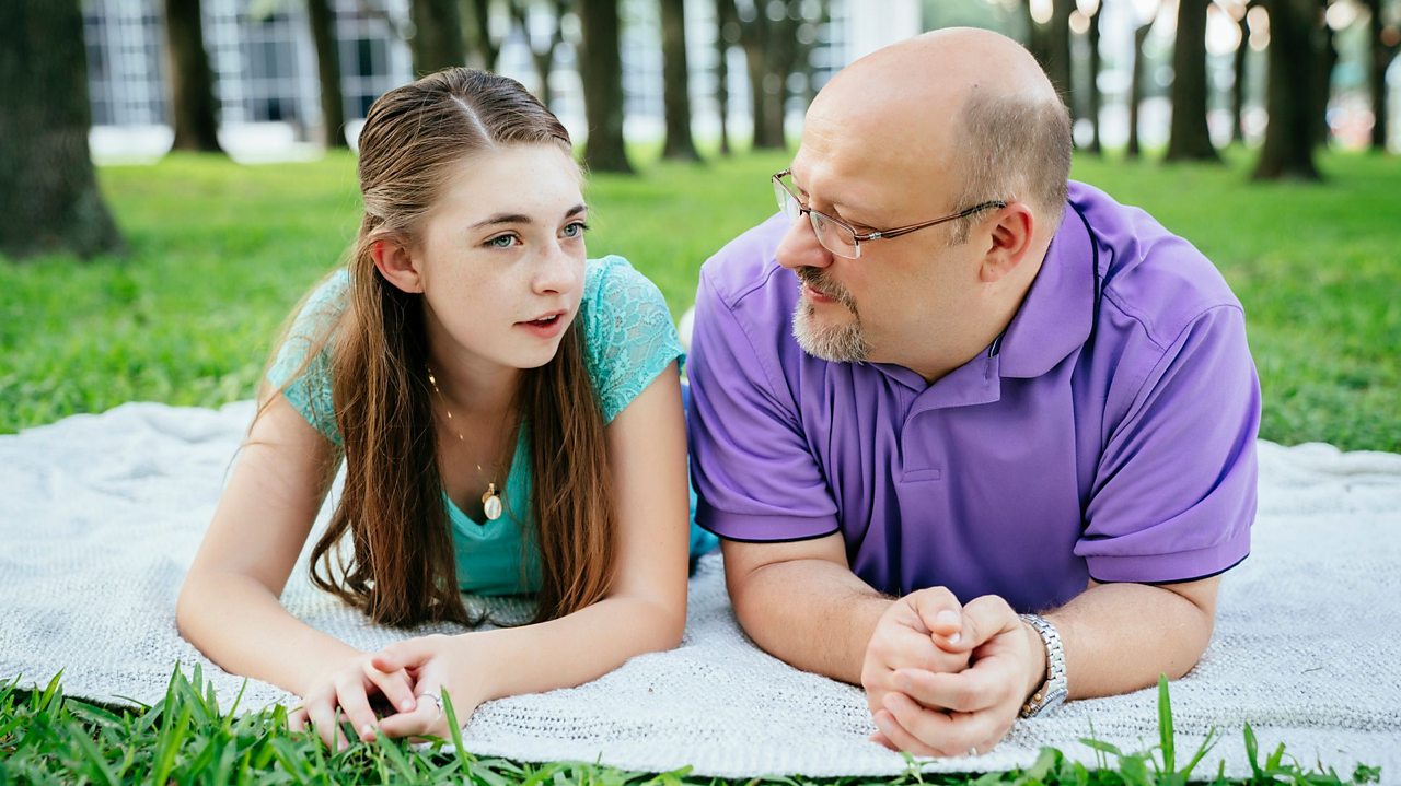 Father and daughter having a conversation in a park