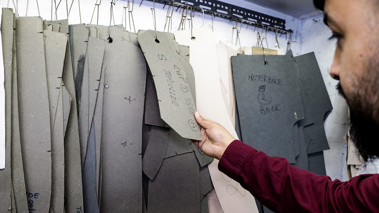Wasim looking through sample patterns for jackets.
