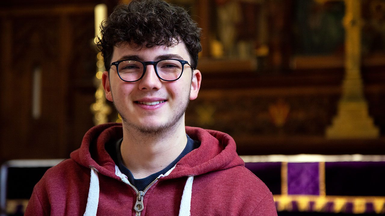 Jacob in church, smiling to camera.