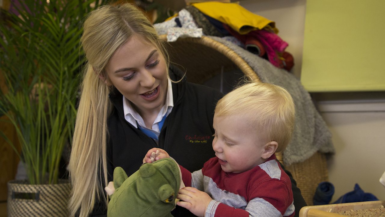 Lucy showing one of the children a toy frog