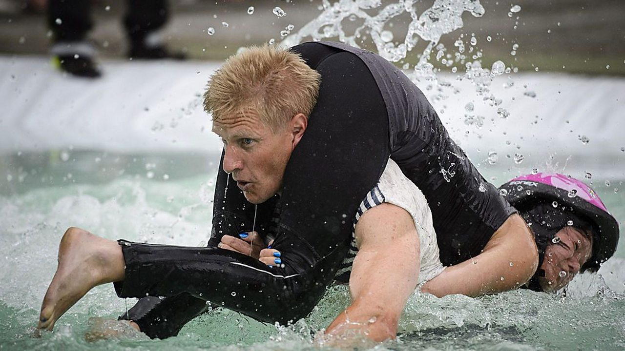 Man carrying woman in Wife-Carrying World Championships in Finland.
