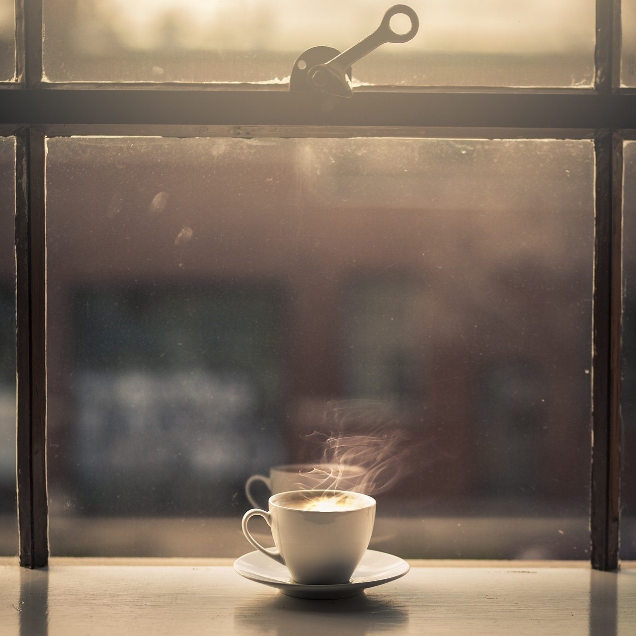 Hot cup of coffee in a sunny window.