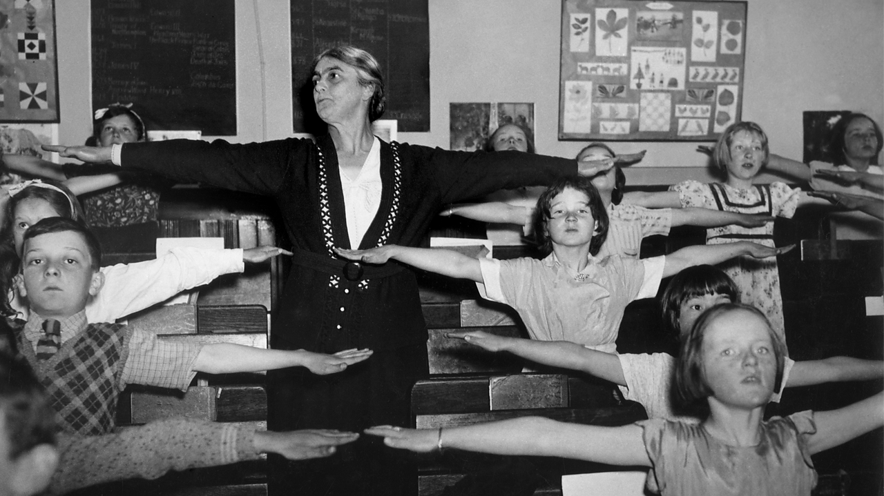 1939 BBC Glasgow: Physical training teacher in School Broadcasting, with pupils at Commercial School.
