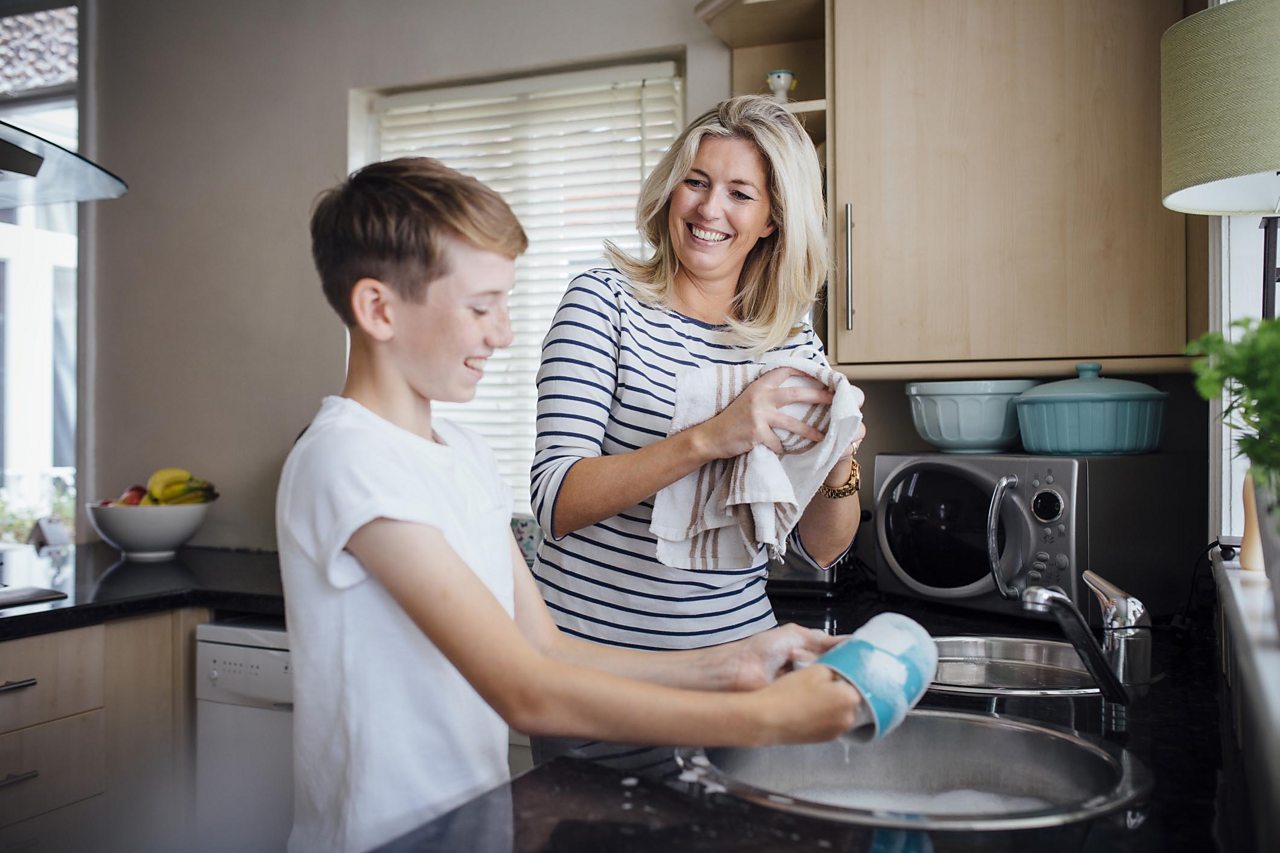 Mum and son washing the dishes