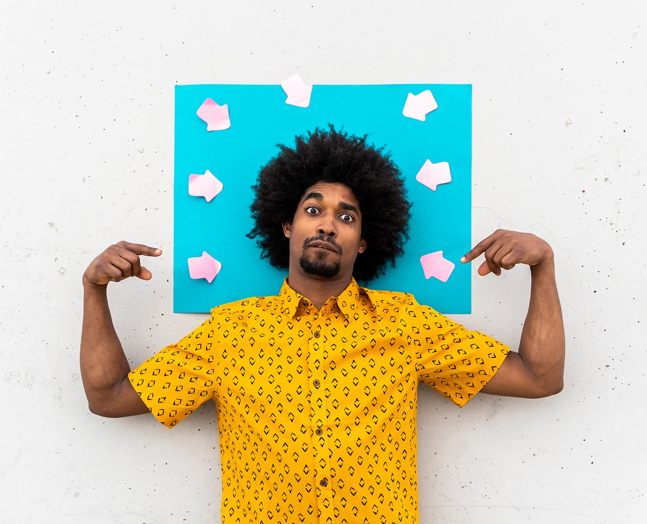 man points to his own head with arrows pointing at himself