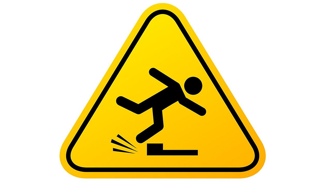 Tripping hazard sign showing a person tripping on a step.