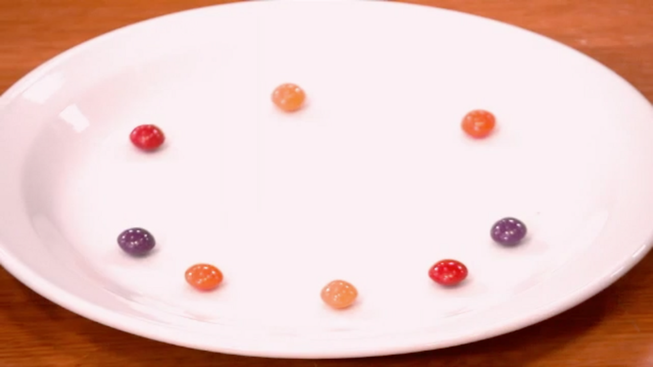Red, orange and purple sweets on a plate.